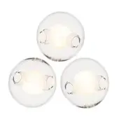 Spherical wall lights with clear rippled glass globes and brushed silver fixtures emit a warm diffused glow in a studio setting.
