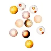 Glass orbs in amber, yellow, pink & gray tones are randomly arranged on white, each with a circular indentation, studio lighting.