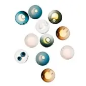 Spherical light fixtures in teal, olive, amber, and white glass emit golden light against a white backdrop, arranged in a dynamic, overlapping composition.
