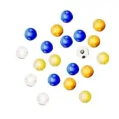 Glass beads in blue, yellow, and clear tones are scattered on a white surface, displaying spherical shapes and subtle surface variations.