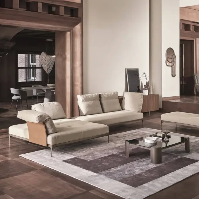 Cassoni Ditre modular sofa, beige fabric upholstery, dark brown leather arms, metal legs, gray and brown patchwork rug, wood framed room.