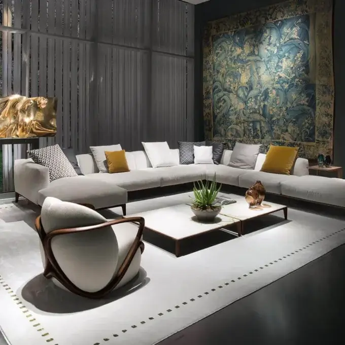 Light gray modular sofa with geometric pillows in a living room featuring a landscape tapestry, wood slat wall, and Giorgetti armchair.