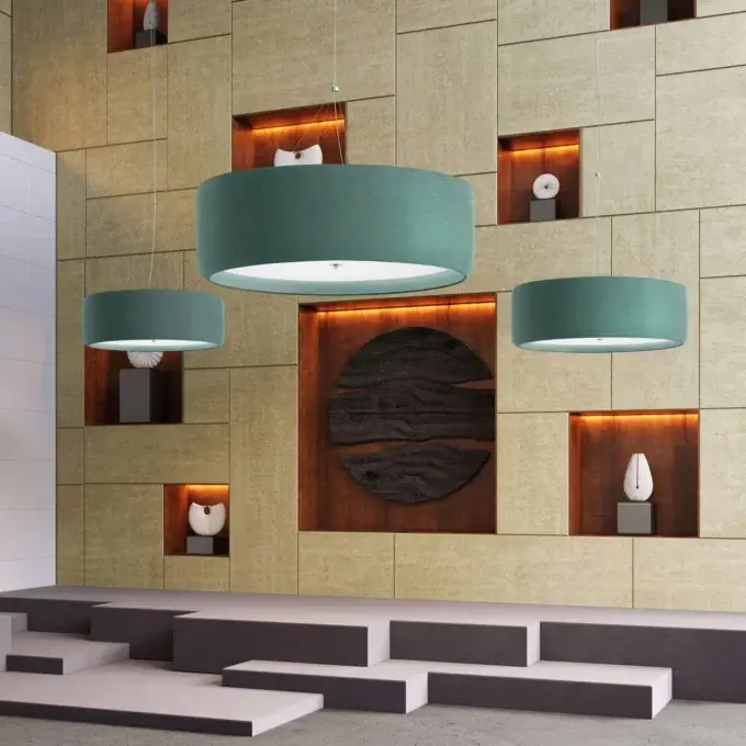 Pendant lights, teal fabric, cylindrical shades suspended in modern interior with beige textured wall panels and gray tiered platform.
