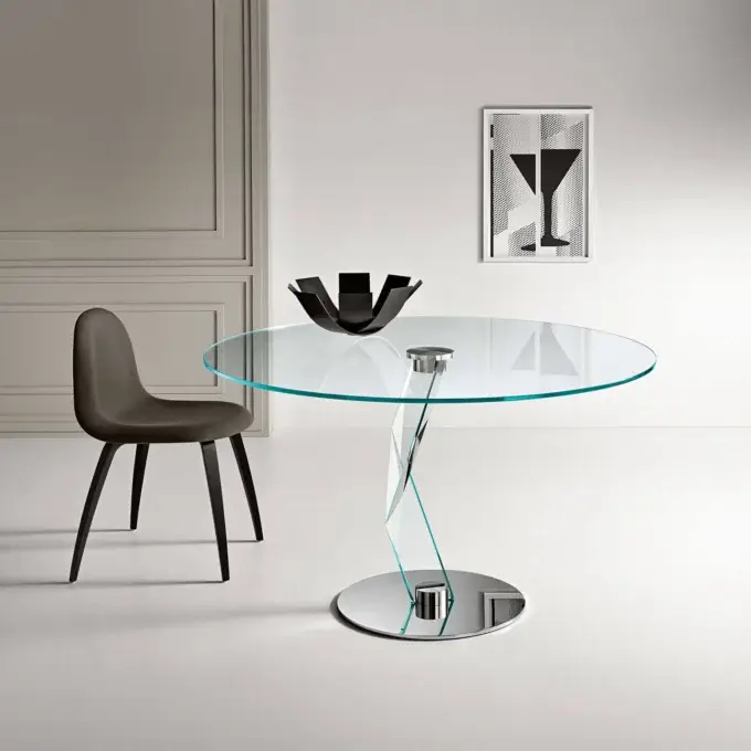 Tonelli dining table, glass and chrome, with circular base and angled acrylic support, paired with gray curved chair.