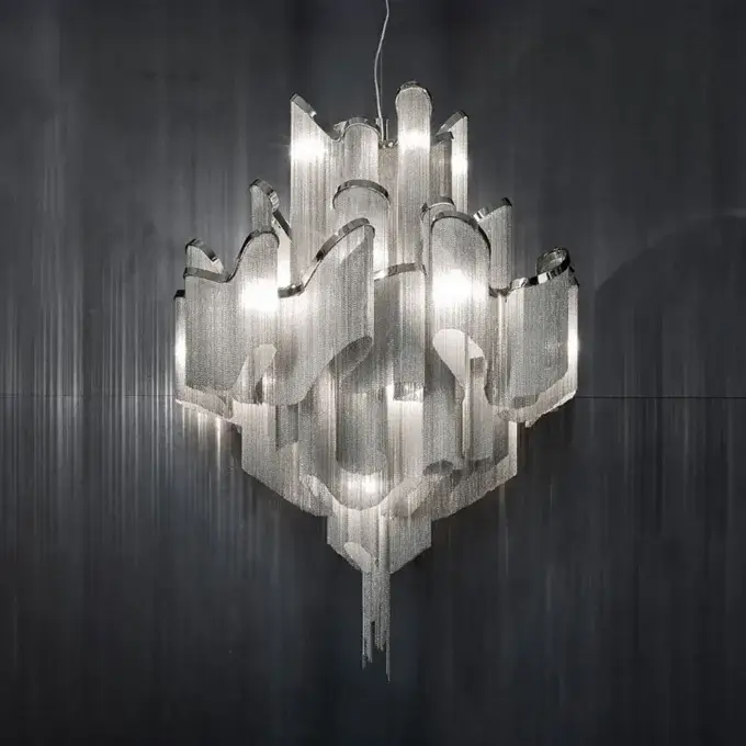 Terzani chandelier, polished metal, layered panels with cascading strands, organic abstract shape, silver and gray tones, studio lighting.
