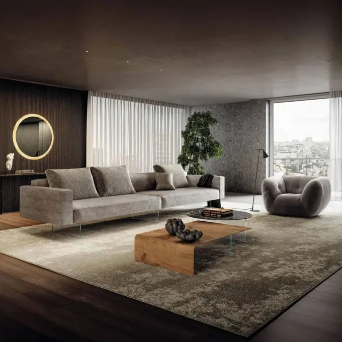 Gray modular sofa with square cushions on a textured rug, beside a dark wood console, mirror, and tree, in a modern living room scene.