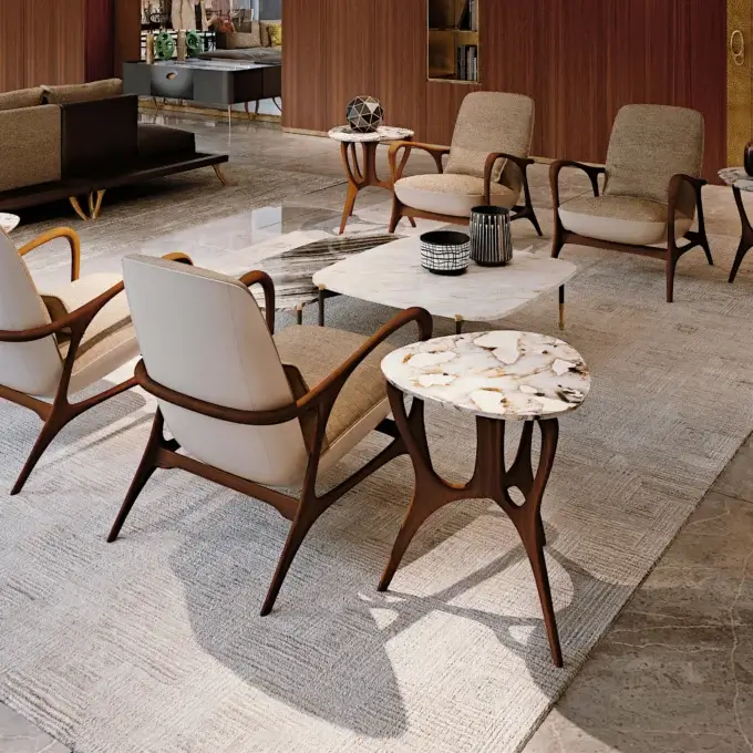 Mid-century armchairs with dark wood frames and beige upholstery, a circular agate coffee table, and matching side tables on a textured rug.