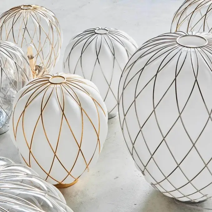 Glass lamps, FontanaArte style, clustered on gray; spherical shapes feature white opaque glass, metallic grid patterns, and clear ribbed glass.