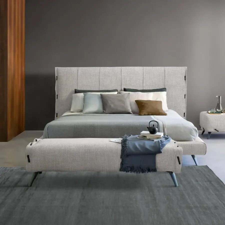 Elegant Bonaldo Cuff bed with light gray woven textile, frog fastenings and muted blue-gray legs crafted in Italy