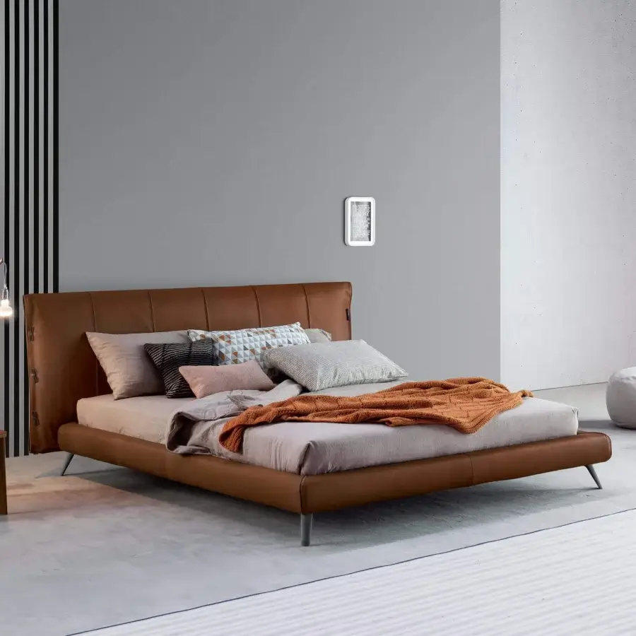 Exceptional Bonaldo Cuff bed with smooth brown leather upholstery and slender cylindrical metal legs with distinctive tailoring