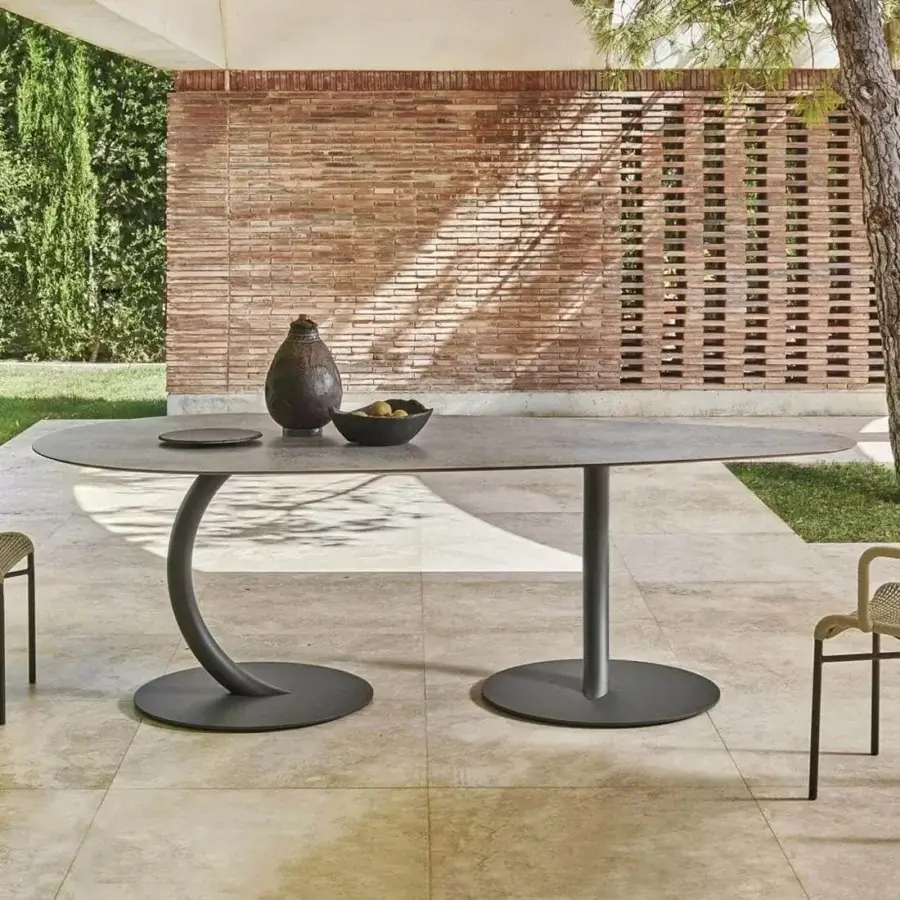 Innovative Varaschin Flexion table with dark gray HPL top and curved metal leg built with a circular base