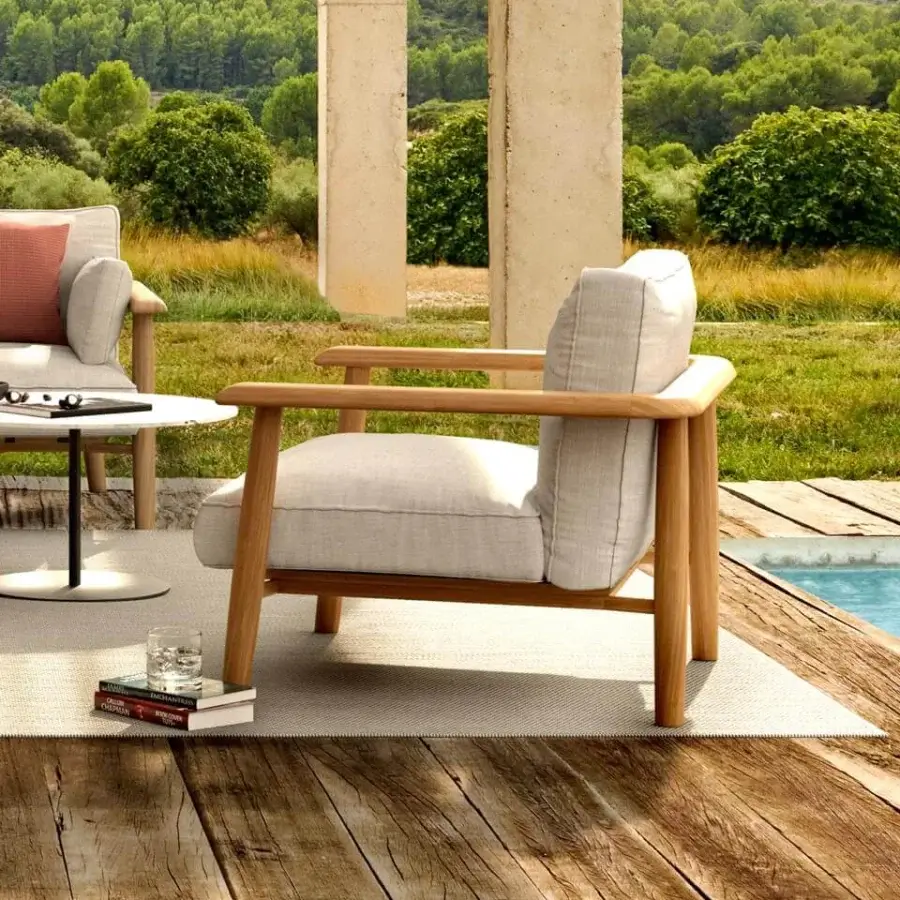 Distinguished Royal Botania Mambo lounge chair built with steel and warm-toned teak wood, upholstered in a neutral textile with a matte finish