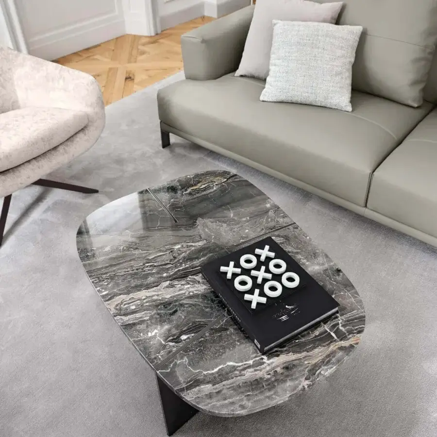 Distinguished Arketipo Rumors coffee table with variegated marble veining and intersecting dark metal blades under a glossy surface