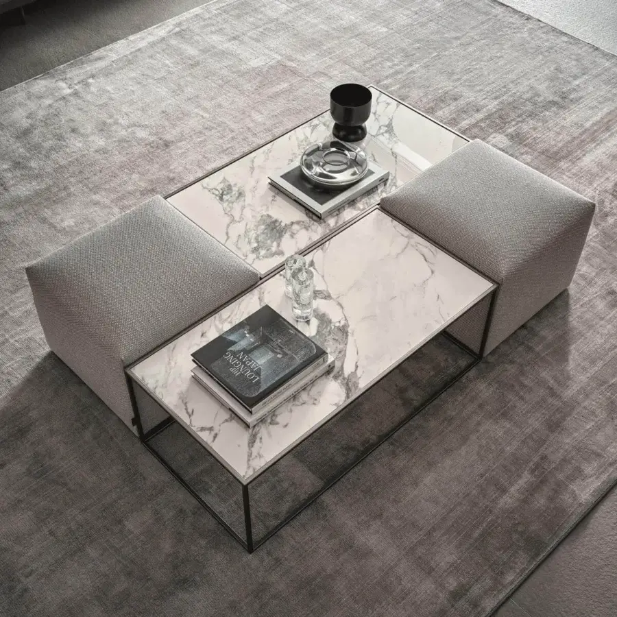 Harmonious Ditre Italia Unit coffee table with black metal base and marble-patterned stoneware top alongside light gray upholstered ottomans