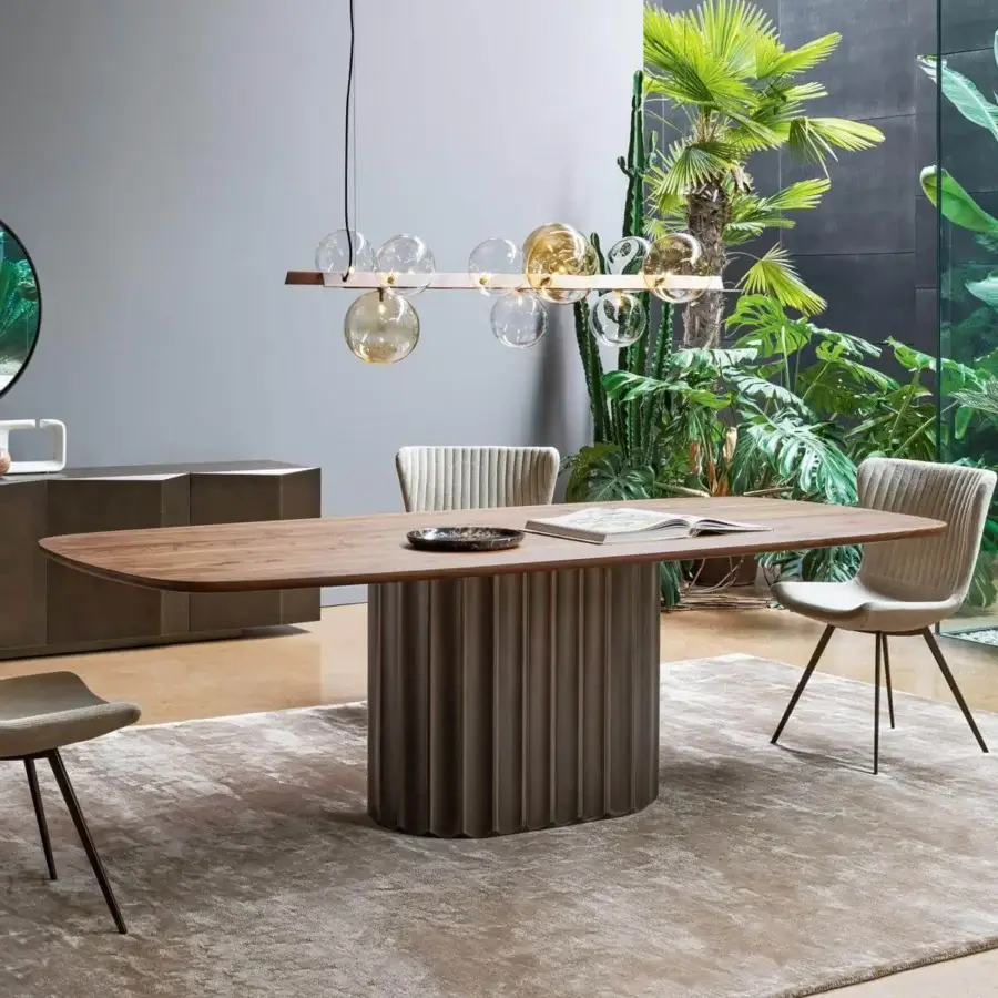 Elegant Bonaldo Dorian table with racetrack wood top and sculptural grooved base inspired by classical architecture in a matte medium brown finish