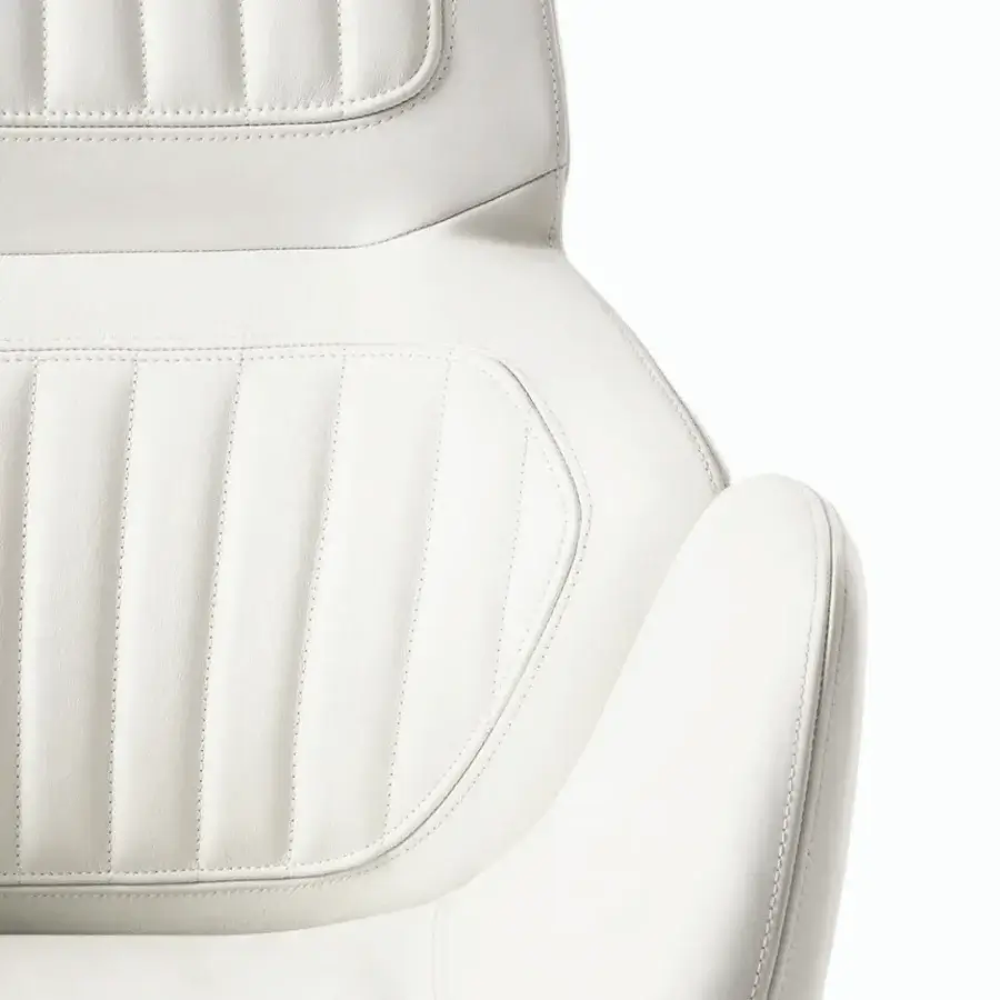 Superior Giorgetti Calathea Bergere chair in white synthetic leather with segmented vertical stitched padding and curved lines
