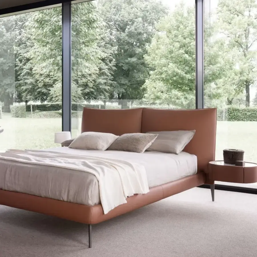 Elegant Presotto Siena bed with tan upholstered frame, slanted pewter finished metal feet and rounded nightstand