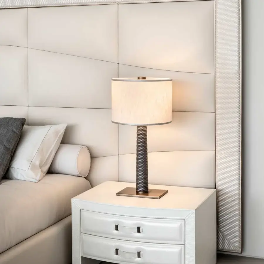 Elegant Rugiano Aura bed upholstered in light cream fabric with a cushioned paneled headboard and embroidered frame