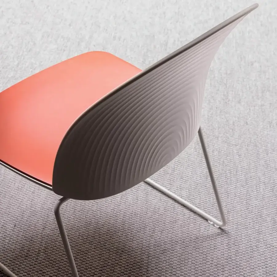 Elegant Presotto Profilo Cristallo chair with coral plastic seat and light gray plastic back with metal sled base