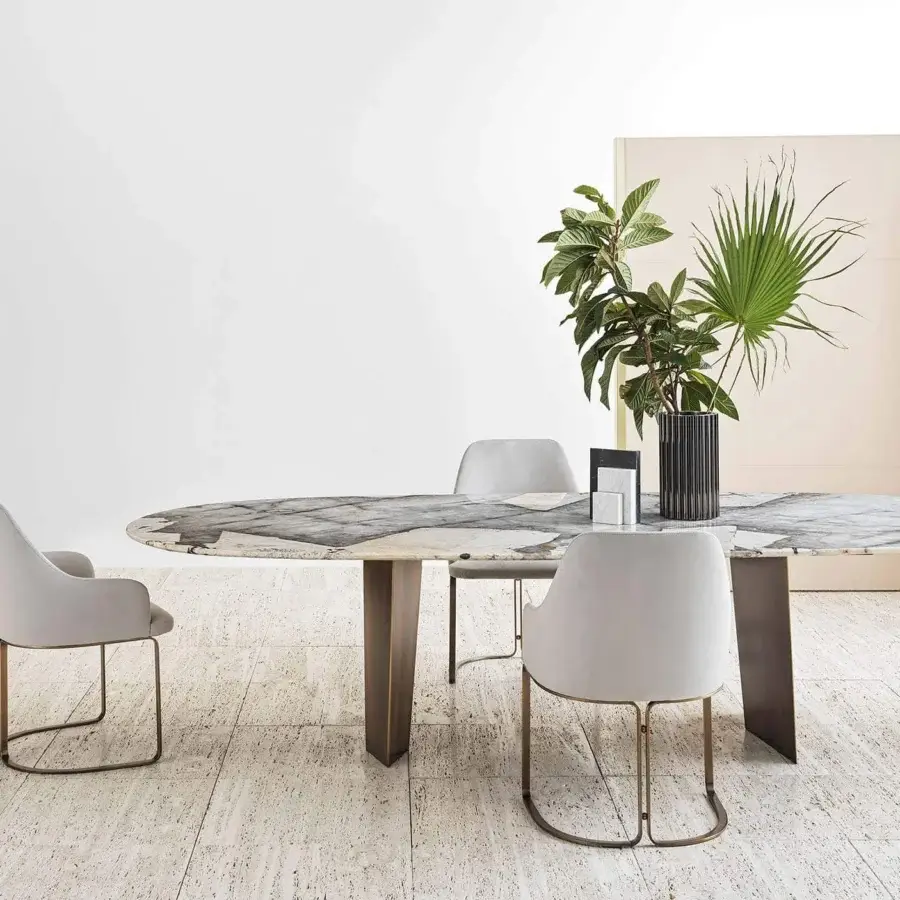 Superior Rugiano Pedro table with oval top exhibiting gray and beige marble and bronzed brass trapezoidal pedestals