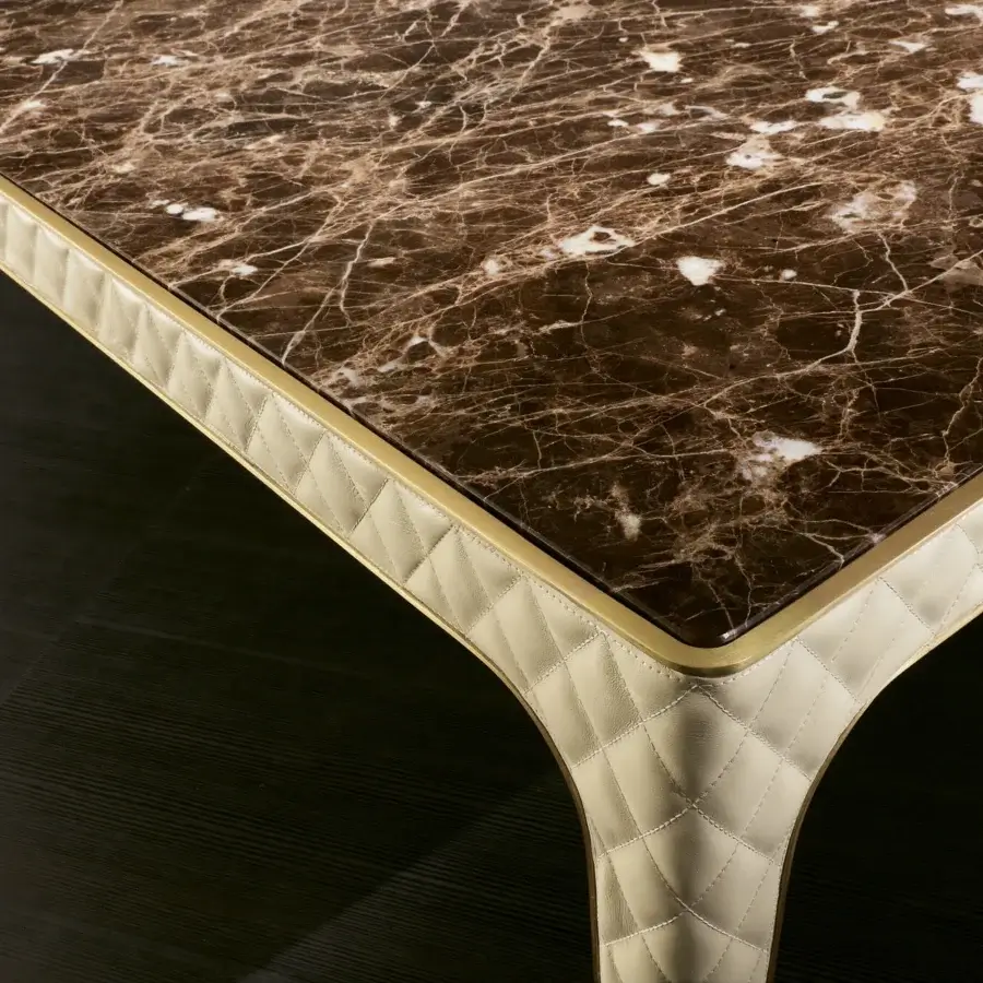 Superior Rugiano Alexander table with brown and white veined marble and bronzed brass detailing in a quilted light beige edge