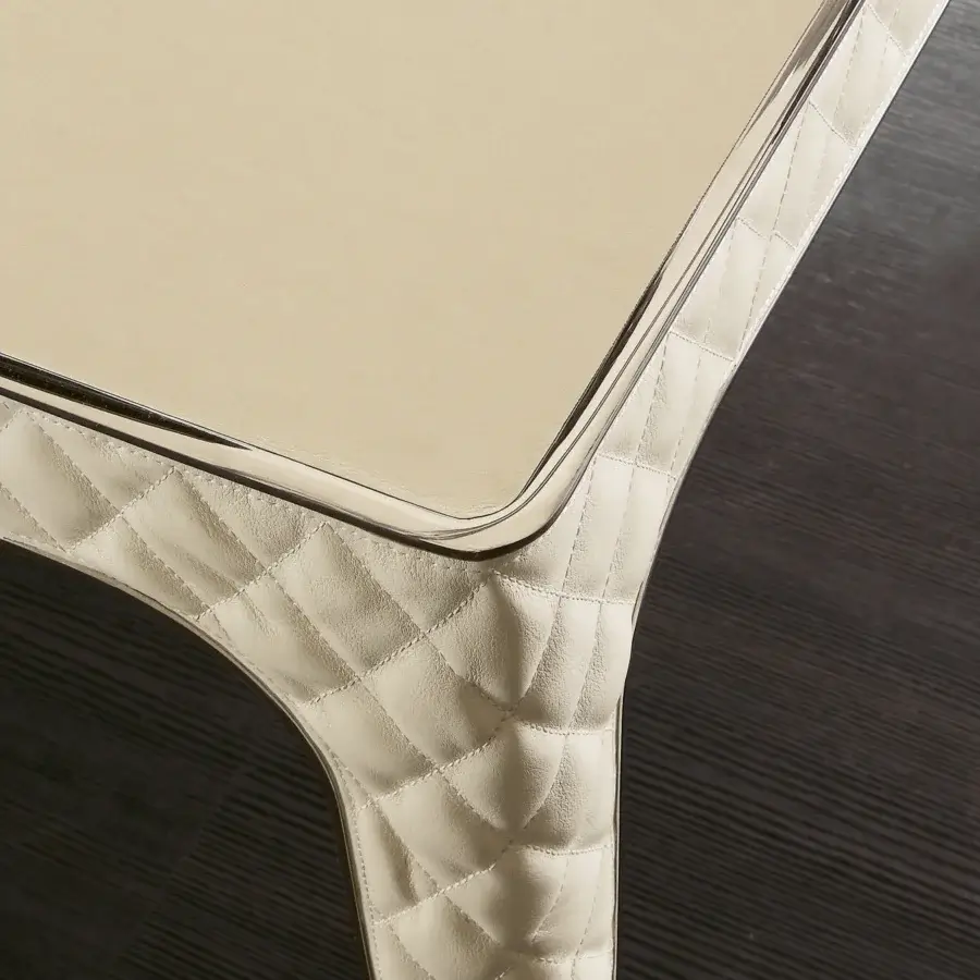 Distinguished Rugiano Alexander table with a light beige tabletop and meticulously crafted quilted base with reflective metal trim
