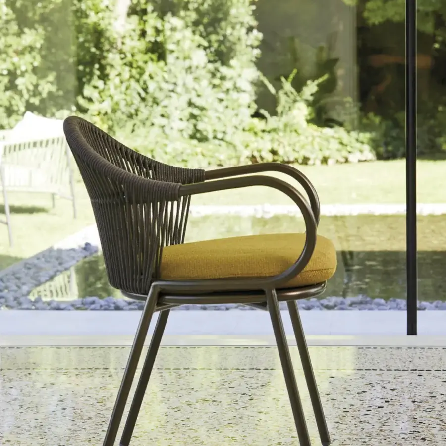 Elegant Roberti Rattan armchair with woven brown backrest and golden-yellow seat cushion crafted in Italy with powder-coated aluminum frame