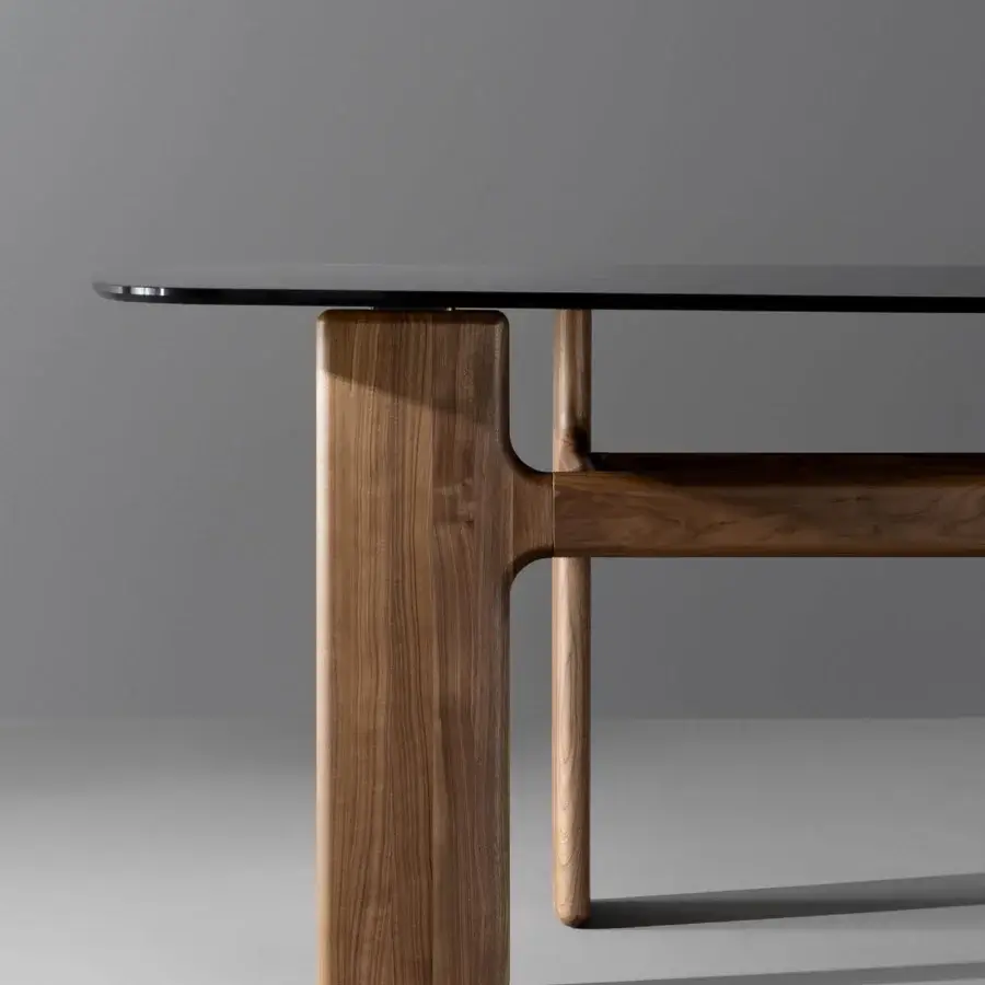 Captivating Bonaldo Hippos table with a dark glass top and warm brown solid wood base exhibiting a dynamic silhouette