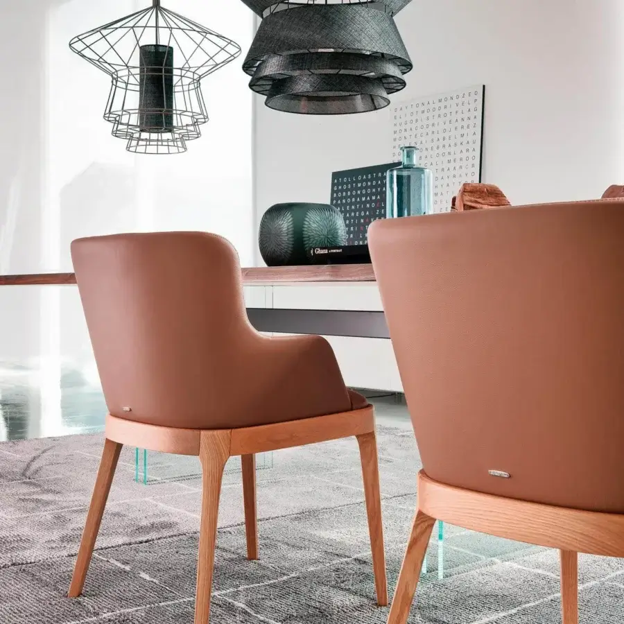 Elegant Cattelan Italia Magda armchair with enveloping backrest and smooth brown synthetic leather upholstery built with a light-toned wooden base