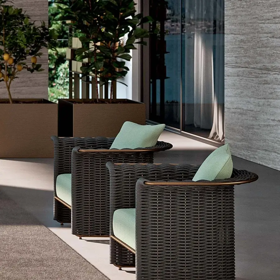 Superior Rugiano Marina lounge chair crafted with dark gray woven rope, a light green cushion and copper-colored metal accents