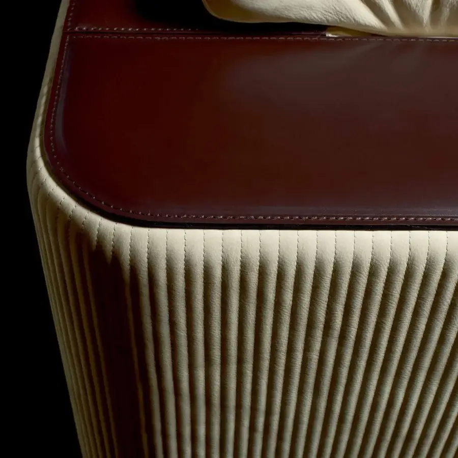 Distinguished Rugiano Vogue sofa exhibits dark brown leather upholstery with quilted, light beige vertical ribbing and metal detailing