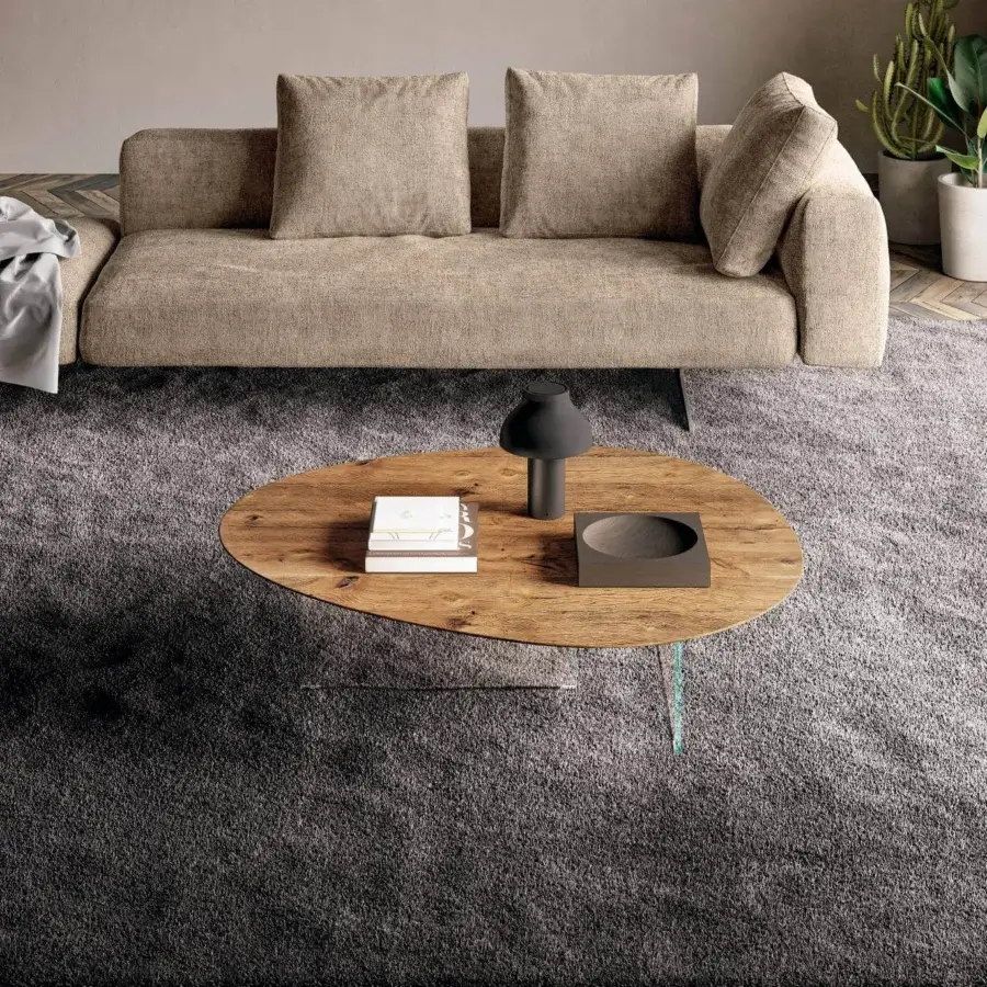 Elegant Lago Pleasure coffee table with irregular curved forms in medium brown wood and transparent legs with matte finish