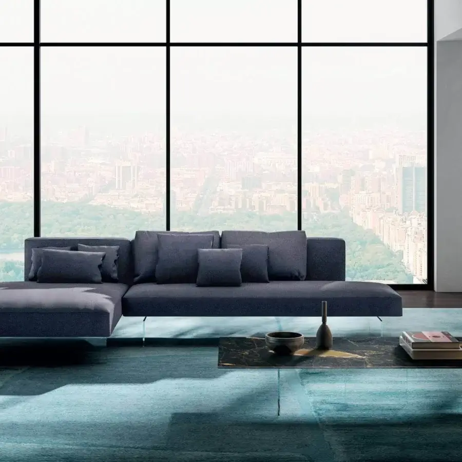 Innovative Lago Air sectional with deep blue textile, matte finish and extra-clear tempered glass legs for personalized configuration