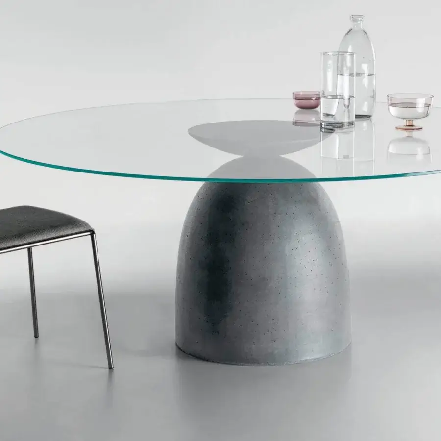 Harmonious Lago Janeiro table with transparent glass top and textured anthracite concrete base inspired by iconic shapes