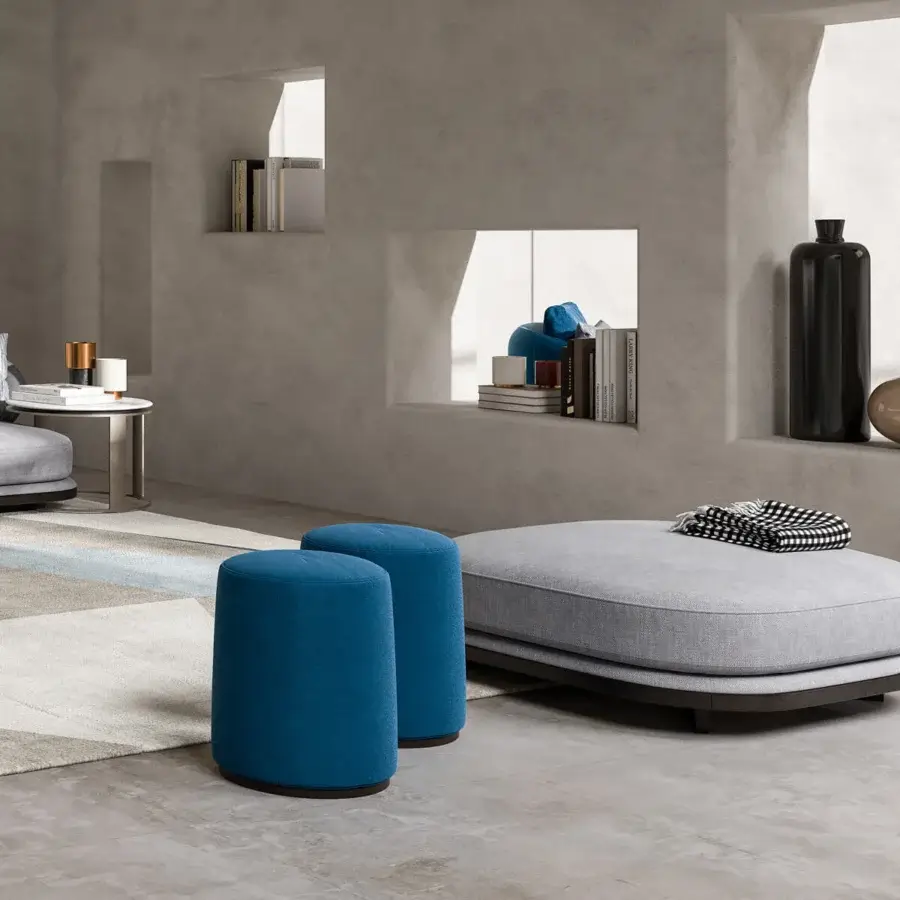 Distinguished CPRN Homood Pierre ottoman in light gray smooth matte textile accompanied by bright blue cylindrical stools