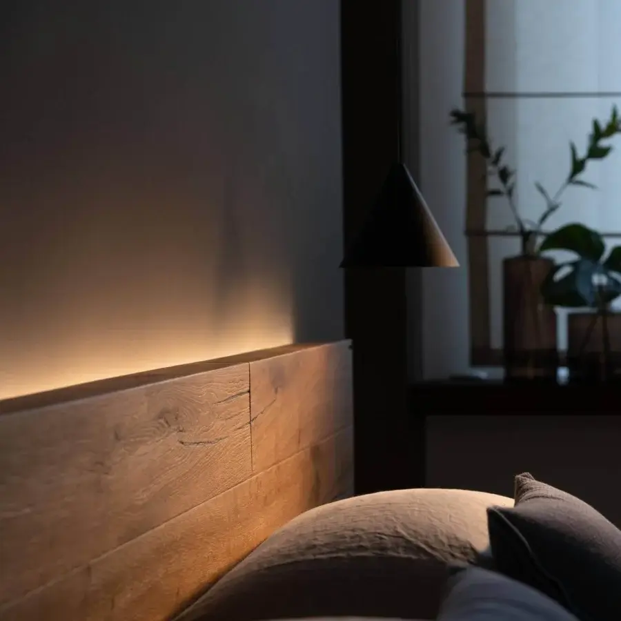 Superior Lago Fluttua bed with horizontally extending wooden headboard and warm illumination in a matte finish