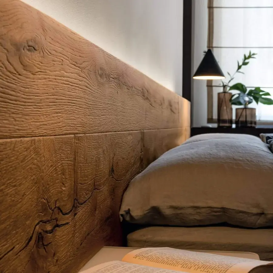 Innovative Lago Fluttua bed with a low wooden headboard exhibiting medium-toned brown finish and natural wood grain patterns