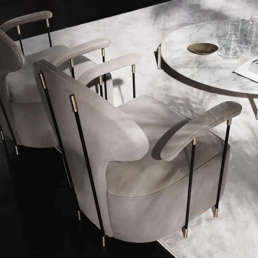 Distinguished Mascheroni Magicabula lounge chair with curved silhouette and light gray textile upholstery built with a black powder-coated steel structure and brass feet
