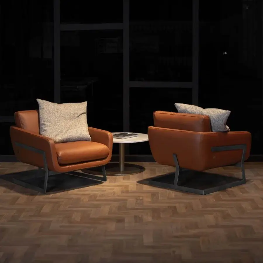 Distinguished WAYNE Enterprises WE-113 lounge chair with warm brown leather upholstery and sleek dark metal frame crafted in Italy
