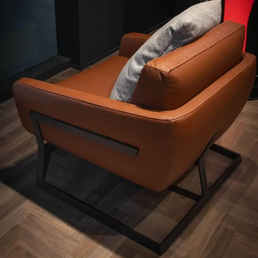Lavish WAYNE Enterprises WE-113 lounge chair with tan leather upholstery and matte metal frame crafted by STUDIO DAINELLI