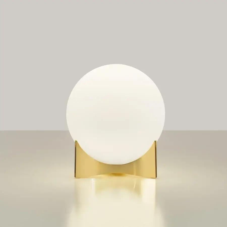 Superior Terzani Oscar lamp with a glowing white glass orb diffuser and glossy golden curved metal structure