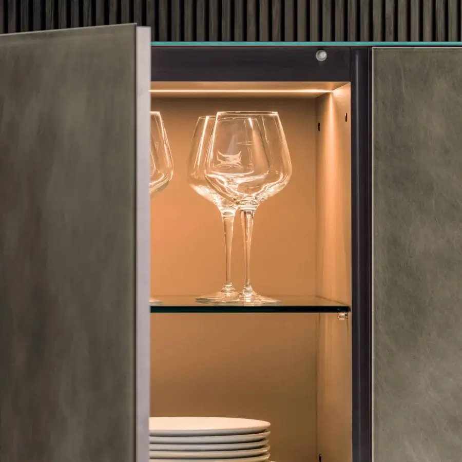 Superior Lago Materia cupboard with wood frame and muted olive green leather-look doors, showcasing tempered-glass shelves within a light tan interior