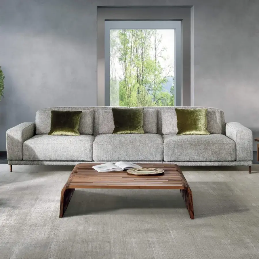 Distinguished Pacini & Cappellini Costanza sofa with light textured fabric upholstery and olive green velvet cushions built on dark wood feet
