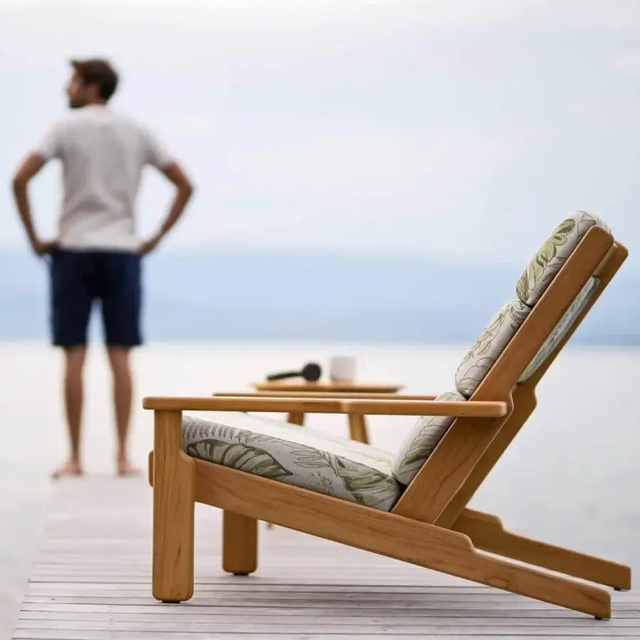 Distinguished Varaschin Bali Bergere lounge chair with light teak wood and green beige leaf-patterned outdoor cushions crafted in Italy