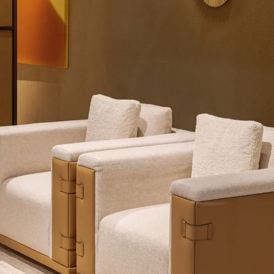 Elegant Turri Atelier lounge chair with light beige textured textile and tan leather-like frame showcasing fabric padding