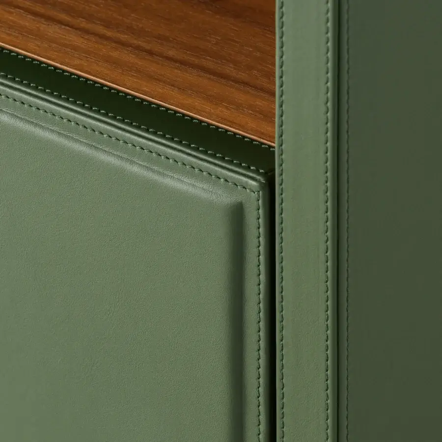 Elegant Turri Atelier nightstand showcasing soft green leather and a warm walnut wood top with impeccable Italian design