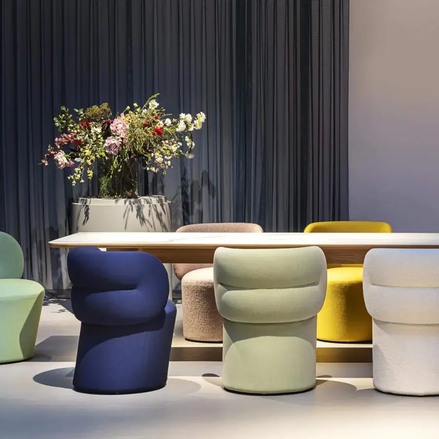 Distinguished Moroso Getlucky chair with rounded backrest and cylindrical base in uniform light green textile with transparent PVC glides