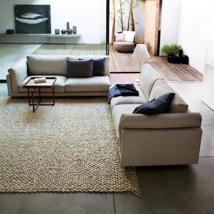 Superior Swan Italia Host sectional with light beige fabric upholstery, dark blue cushions and a powder-coated metal base