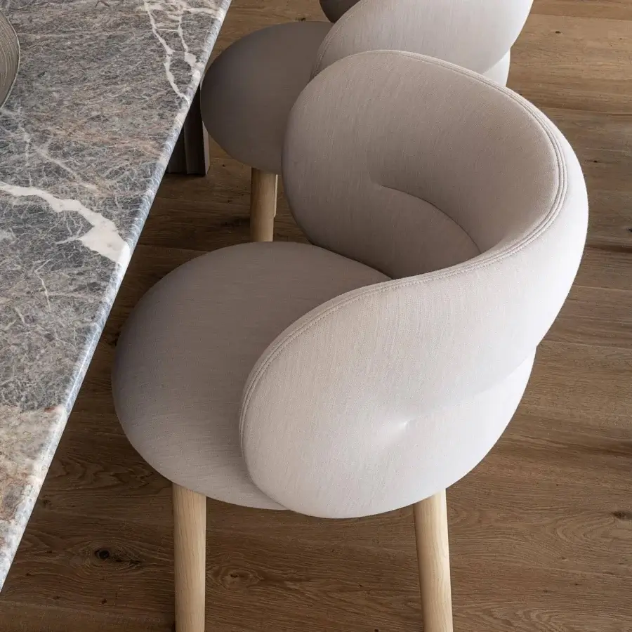 Distinctive Moroso Getlucky chair with comfortable silhouette in light beige textile and varnished ash wood legs