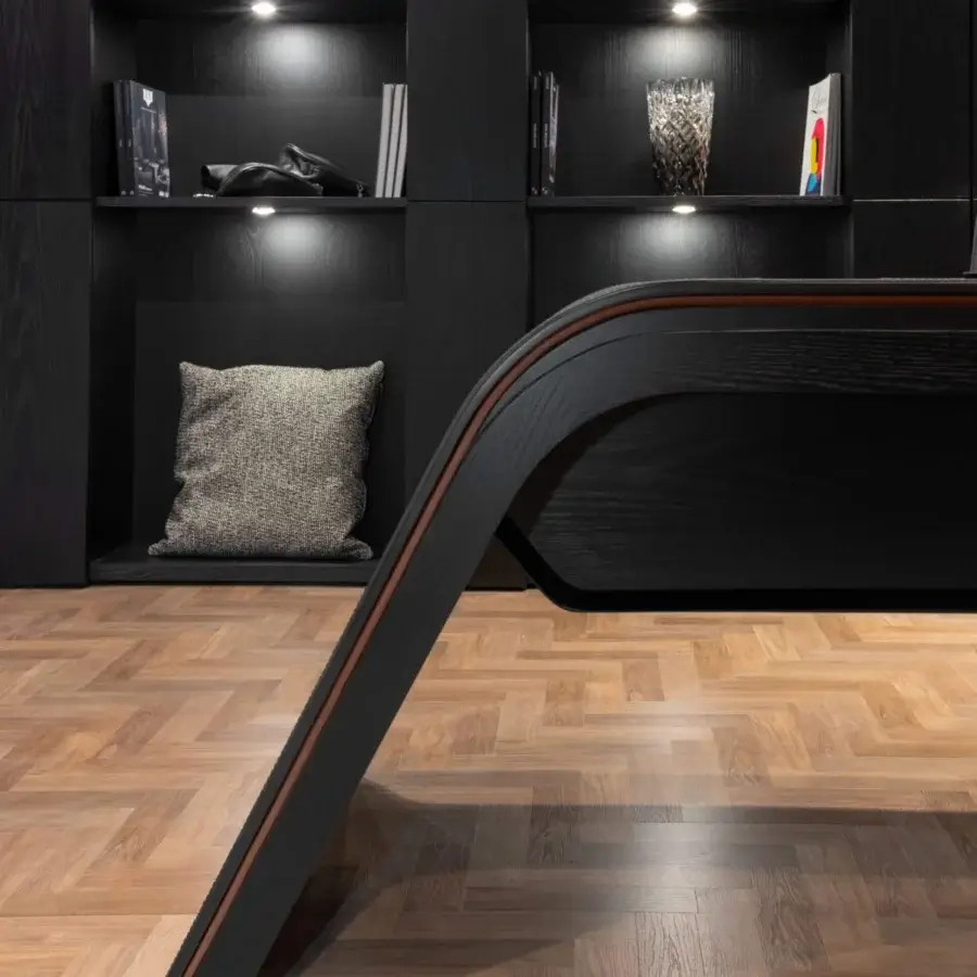 Exclusive Wayne Enterprises WE-024 desk upholstered in dark leather with a curved silhouette and lacquered undertop